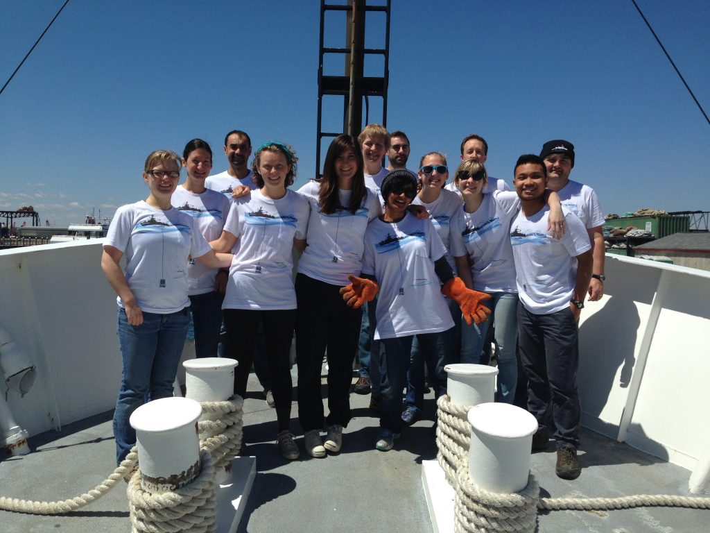 The team of researchers posing onboard the research vessel.